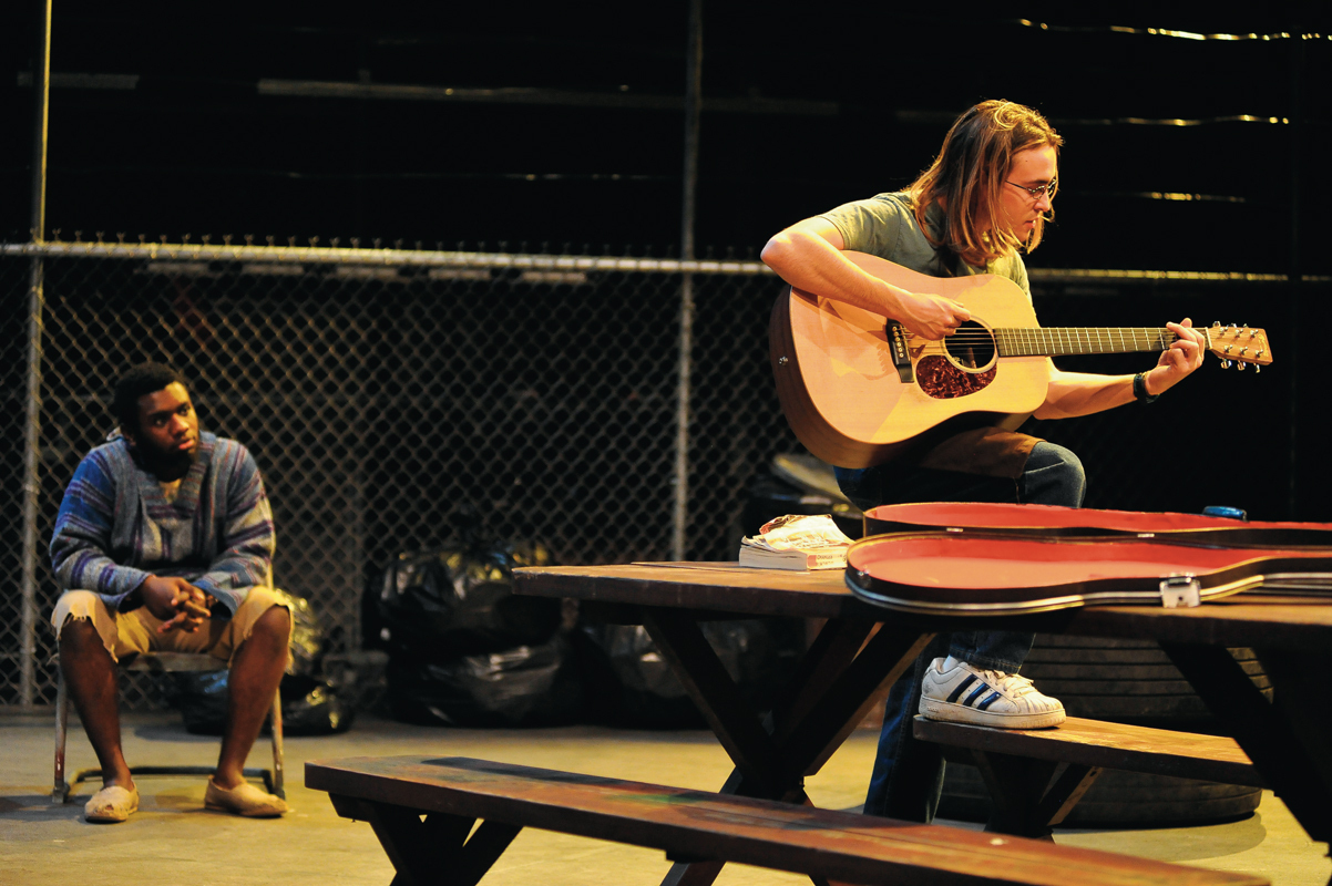 Evan (Luke LaMontagne) concludes _The Aliens_ with a stirring and messy rendition of the folk tune, "The Hammer Song," while KJ (Jean Floradin) quietly looks on. (credit: Courtesy of Louis Stein)