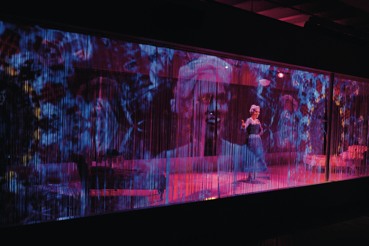 The set for the *The Glass Menagerie* featured a number of different projections cast onto a screen that divided the actors from the audience. (credit: Courtesy of Louis Stein)