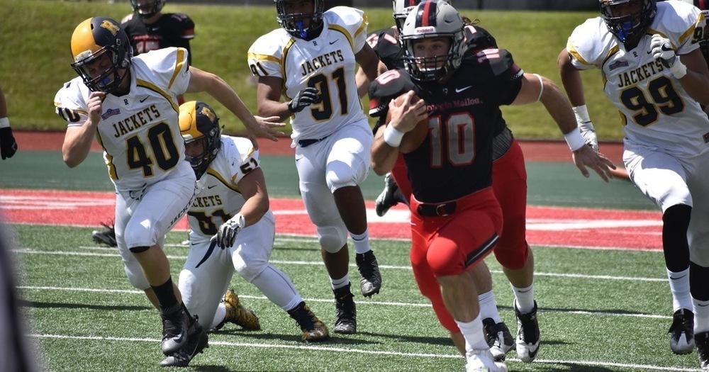 Senior running back Sam Benger breaks past Rochester’s defenders. (credit: Courtesy of CMU Athletics)